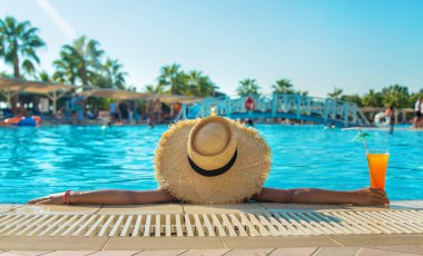 Çocuk havuz kenarında bir kokteyl içiyor. Seçici odaklanma. Çocuk.