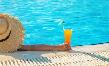 Çocuk havuz kenarında bir kokteyl içiyor. Seçici odaklanma. Çocuk.