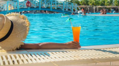 Çocuk havuz kenarında bir kokteyl içiyor. Seçici odaklanma. Çocuk.