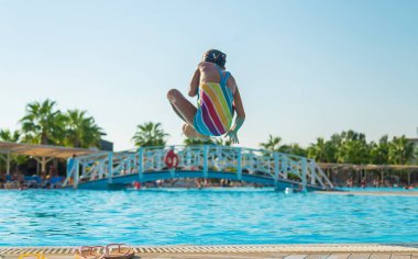 Çocuk havuza atlıyor. Atlıyor. Seçici odaklanma. Çocuk.