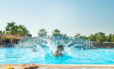 Çocuk havuza atlıyor. Atlıyor. Seçici odaklanma. Çocuk.