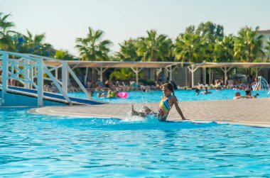 Çocuk ayaklarını havuzun kenarına serpti. Seçici odaklanma. Çocuk.