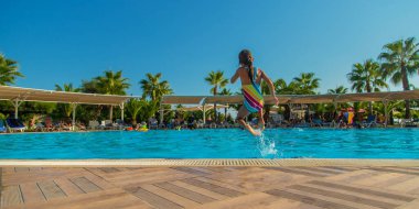 Çocuk havuza atlıyor. Atlıyor. Seçici odaklanma. Çocuk.