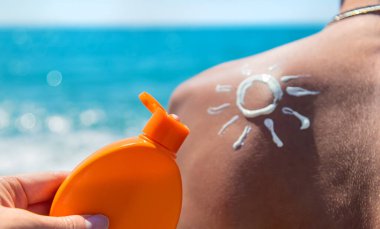 Sunscreen on the man back. Selective focus. People.