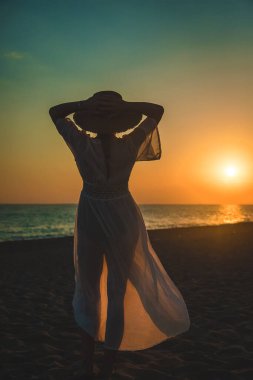 Woman on the beach at sunset. Selective focus. Sea.