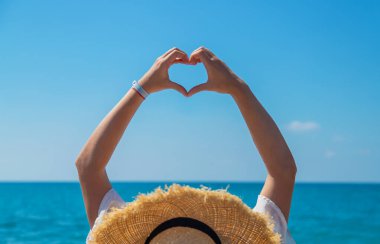 Woman with hat on the beach. Selective focus. Sea.