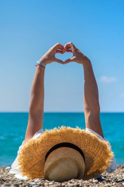 Woman with hat on the beach. Selective focus. Sea.