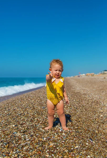 Bebé Está Sentado Playa Junto Mar Enfoque Selectivo Niño —  Fotos de Stock