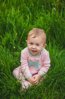 Bebek çimlerin üzerinde yatıyor. Seçici odaklanma. Doğa.