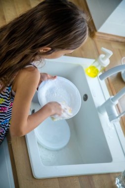 Çocuklar mutfakta bulaşıkları yıkarlar. Seçici odaklanma. Çocuk.