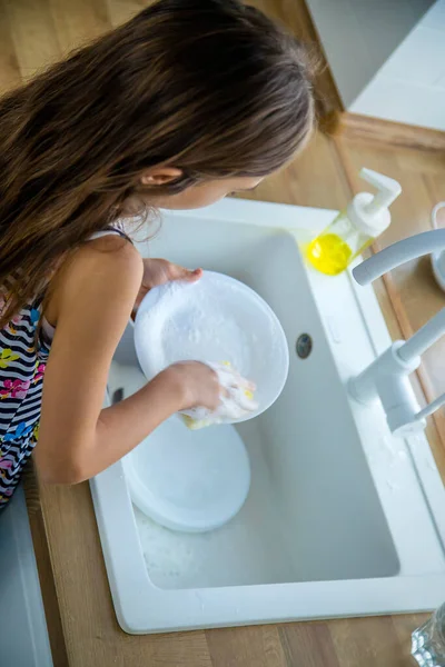 Çocuklar mutfakta bulaşıkları yıkarlar. Seçici odaklanma. Çocuk.