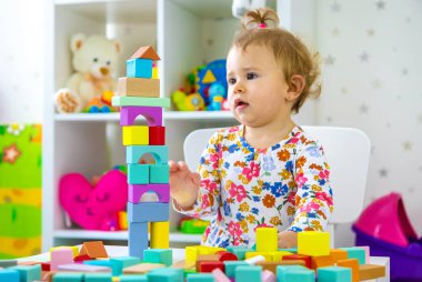 Çocuk odada oyuncaklarla oynuyor. Seçici odaklanma. Bebeğim..