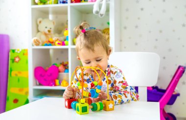 Çocuk odada oyuncaklarla oynuyor. Seçici odaklanma. Bebeğim..