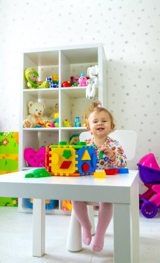 Çocuk odada oyuncaklarla oynuyor. Seçici odaklanma. Bebeğim..