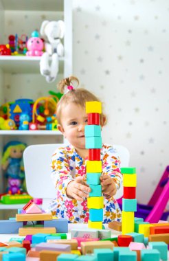 Çocuk odada oyuncaklarla oynuyor. Seçici odaklanma. Bebeğim..