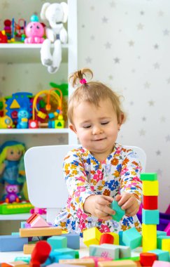 Çocuk odada oyuncaklarla oynuyor. Seçici odaklanma. Bebeğim..