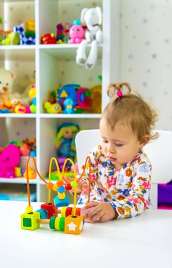 Çocuk odada oyuncaklarla oynuyor. Seçici odaklanma. Bebeğim..