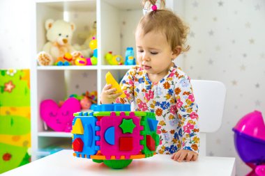 Çocuk odada oyuncaklarla oynuyor. Seçici odaklanma. Bebeğim..