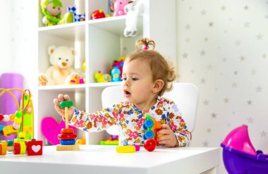 Çocuk odada oyuncaklarla oynuyor. Seçici odaklanma. Bebeğim..