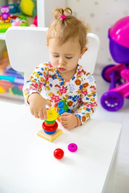 Çocuk odada oyuncaklarla oynuyor. Seçici odaklanma. Bebeğim..