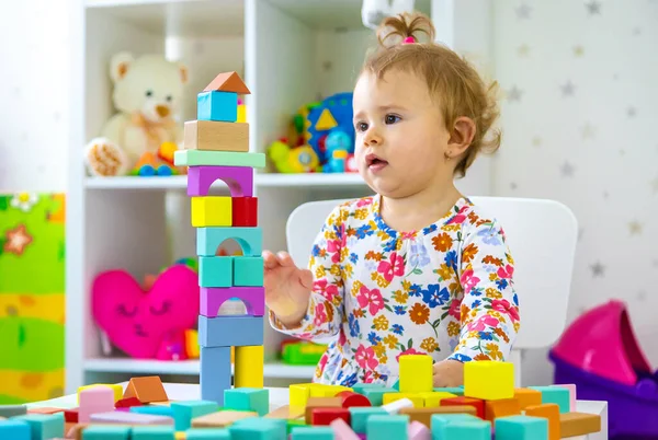 Çocuk odada oyuncaklarla oynuyor. Seçici odaklanma. Bebeğim..