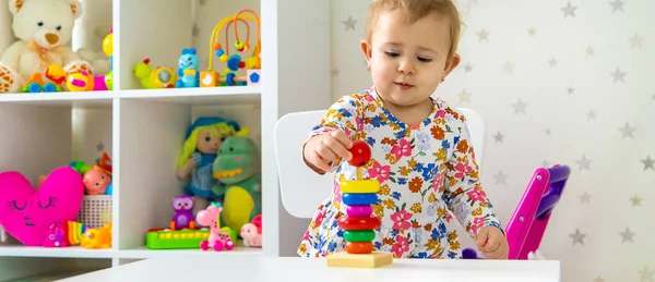 Çocuk odada oyuncaklarla oynuyor. Seçici odaklanma. Bebeğim..