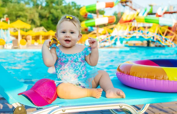 El bebé está sentado junto a la piscina. Enfoque selectivo. — Foto de Stock