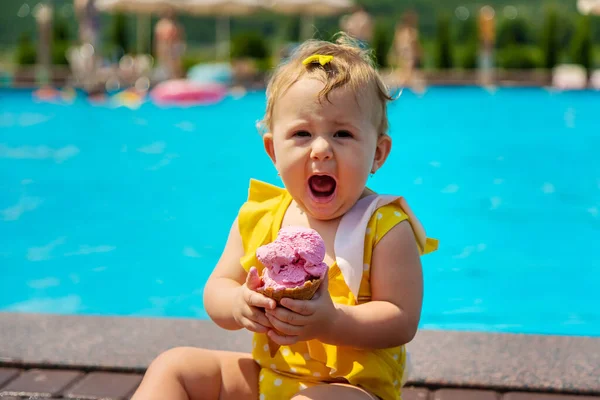 Çocuk havuzun yanında dondurma yiyor. Seçici odak. — Stok fotoğraf