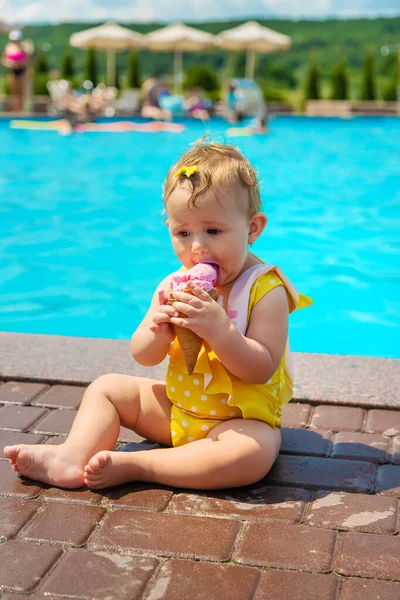 Çocuk havuzun yanında dondurma yiyor. Seçici odak. — Stok fotoğraf