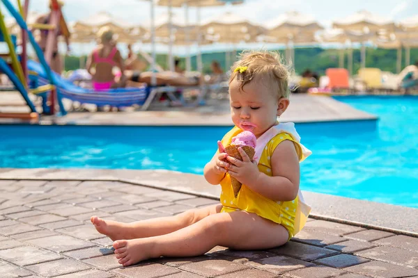 Дитина їсть морозиво біля басейну. Вибірковий фокус . — стокове фото