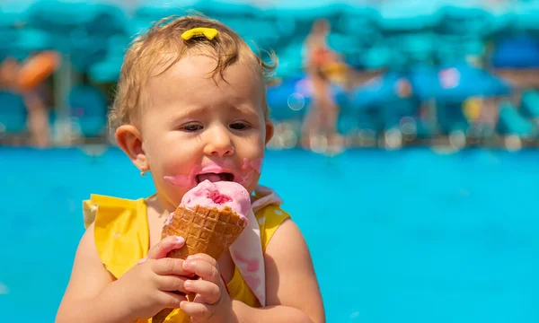 Ребенок ест мороженое у бассейна. Селективный фокус. — стоковое фото
