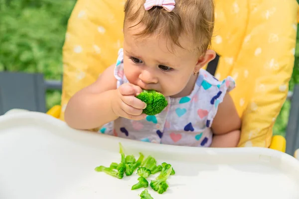 Dítě jí kousky brokolice zeleniny. Selektivní zaměření. — Stock fotografie