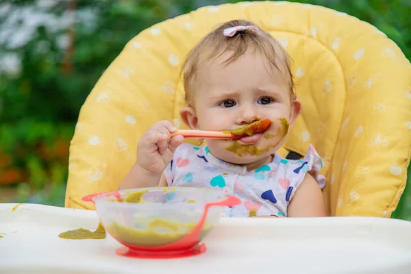 El bebé está comiendo puré de verduras. Enfoque selectivo. —  Fotos de Stock