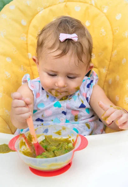 El bebé está comiendo puré de verduras. Enfoque selectivo. —  Fotos de Stock