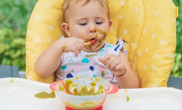 El bebé está comiendo puré de verduras. Enfoque selectivo. —  Fotos de Stock