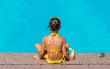 Çocuğun arkasında güneş kremi var. Seçici odak.