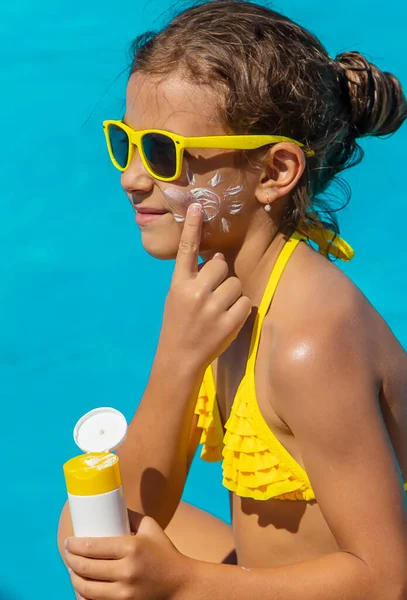 Protetor solar perto da piscina no rosto da criança. Foco seletivo. — Fotografia de Stock