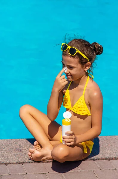 Protector solar cerca de la piscina en la cara del niño. Enfoque selectivo. — Foto de Stock
