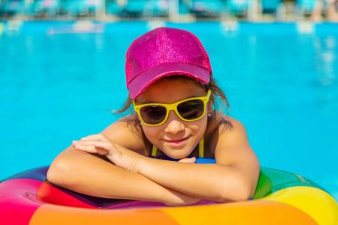 Çocuk havuzda bir daire içinde yüzüyor. Seçici odak.