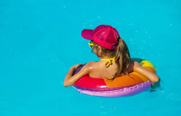 L'enfant nage dans la piscine en cercle. Concentration sélective. — Photo