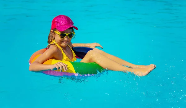 L'enfant nage dans la piscine en cercle. Concentration sélective. — Photo