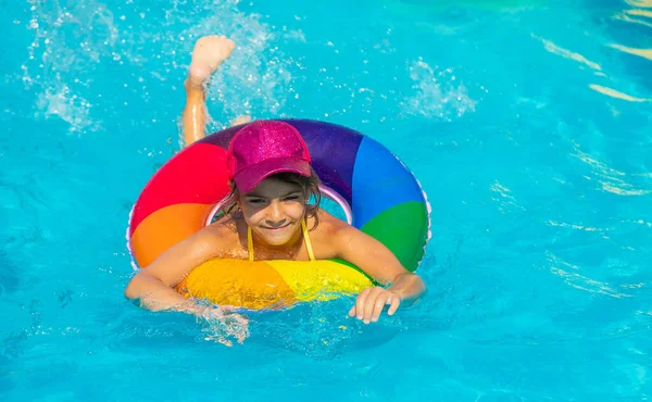 The child swims in the pool in a circle. Selective focus. — Stock Photo, Image