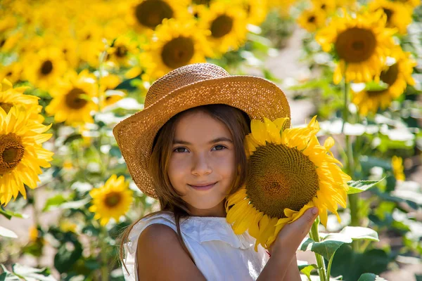 Mädchen in einem Sonnenblumenfeld. Selektiver Fokus. — Stockfoto