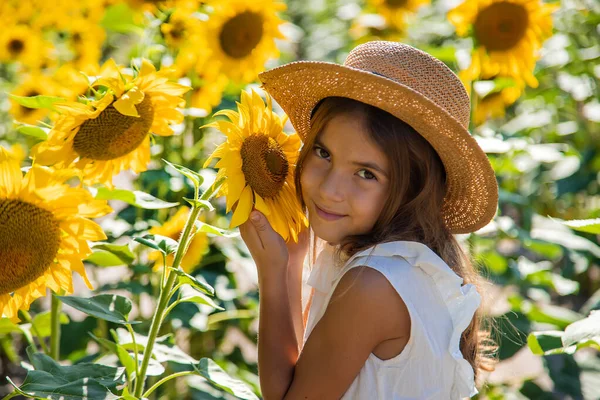 Mädchen in einem Sonnenblumenfeld. Selektiver Fokus. — Stockfoto