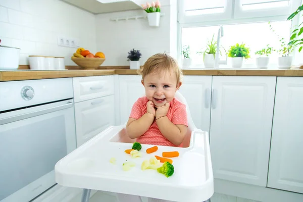 Дитина їсть овочі на стільці. Вибірковий фокус . — стокове фото