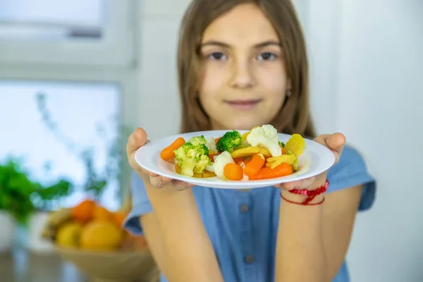 어린이는 의자에서 야채를 먹는다. 선택적 초점. — 스톡 사진