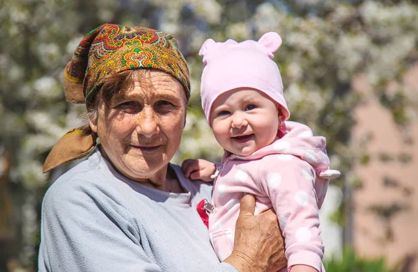 Die Großmutter hält ihre Enkelin auf dem Arm. Selektiver Fokus. — Stockfoto