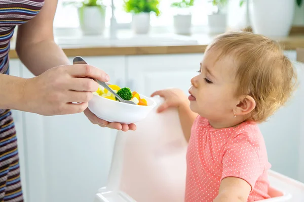 Dítě jí zeleninu na židli. Selektivní zaměření. — Stock fotografie