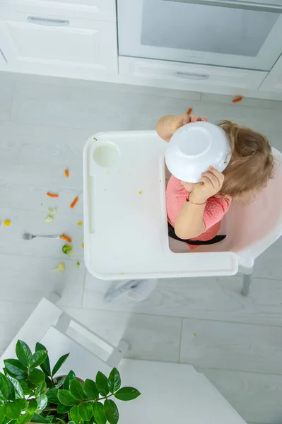 Dítě jí zeleninu na židli. Selektivní zaměření. — Stock fotografie
