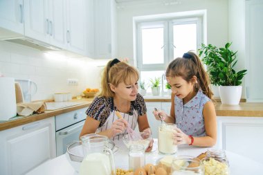 Anne ve çocuk mutfakta hamur işi pişirir. Mutfakta hamuru hazırlar. Seçici odaklanma. İnsanlar.